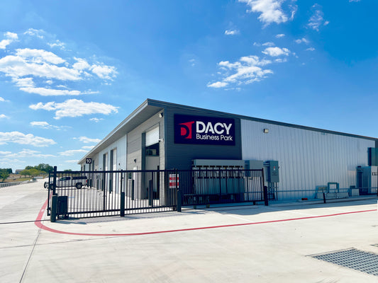 Building 10 flex warehouse with Dacy Business Park sign, gated access, and roll-up doors in Kyle, TX