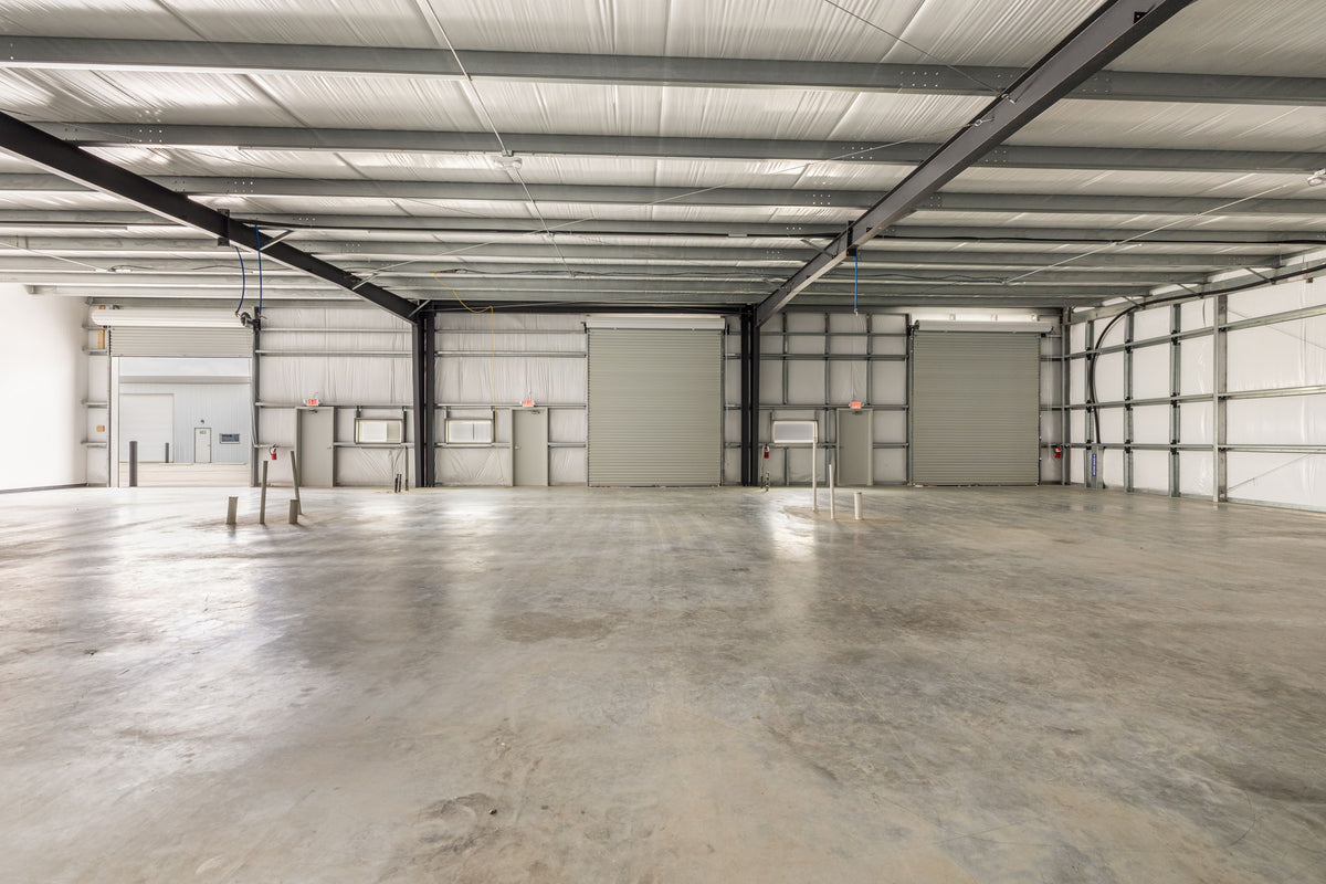 Open Dacy Business Park warehouse bay with roll-up doors — Kyle, TX